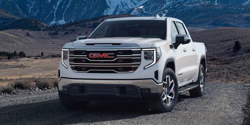 A white 2024 GMC Sierra 1500 parked on rugged terrain